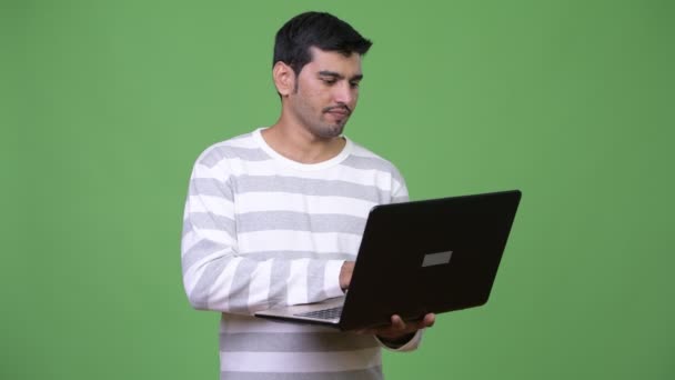 Joven hombre persa guapo usando portátil — Vídeos de Stock