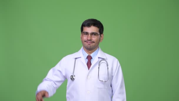 Молодой красивый персидский врач указывает на — стоковое видео