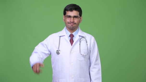 Ung snygg persisk man läkare pekar uppåt — Stockvideo