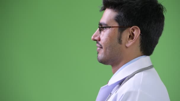 Profile view of young handsome Persian man doctor — Stock Video