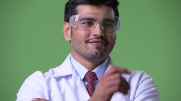 Jovem bonito persa homem médico vestindo óculos de proteção pensando — Vídeo de Stock