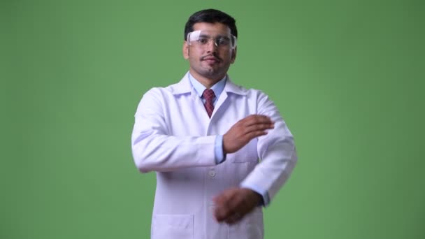 Ung snygg persisk man läkare bär skyddsglasögon med armarna korsade — Stockvideo