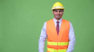 Genç yakışıklı Farsça adam inşaat işçisi bir şeyler gösteriyor
