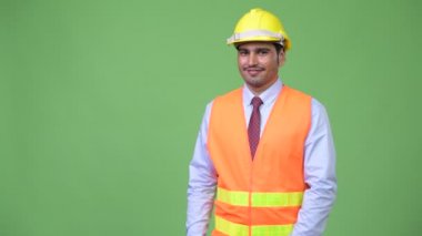 Genç yakışıklı Farsça adam inşaat işçisi bir şeyler gösteriyor