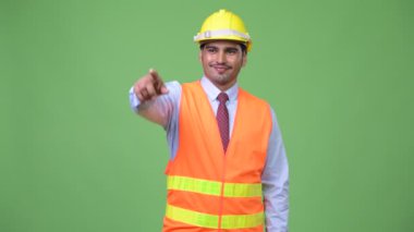 Genç yakışıklı Farsça adam inşaat işçisi işaret parmağı