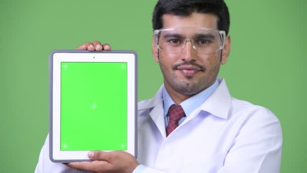 Joven guapo médico persa hombre con gafas protectoras que muestran tableta digital — Vídeos de Stock