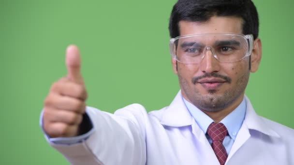 Jeune bel homme persan médecin portant des lunettes de protection donnant pouces vers le haut — Video