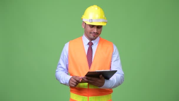 Jovem bonito persa homem construção trabalhador pensando enquanto segurando prancheta — Vídeo de Stock