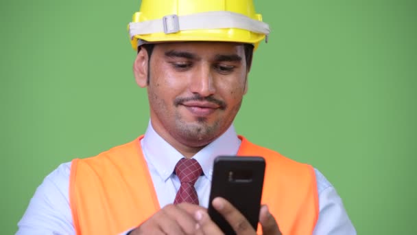 Περσικά-όμορφος νεαρός εργαζόμενος κατασκευή χρησιμοποιώντας το τηλέφωνό — Αρχείο Βίντεο