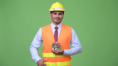 Ev heykelcik tutan genç yakışıklı Farsça adam inşaat işçisi