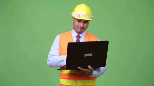 Joven hombre persa guapo trabajador de la construcción utilizando ordenador portátil — Vídeos de Stock