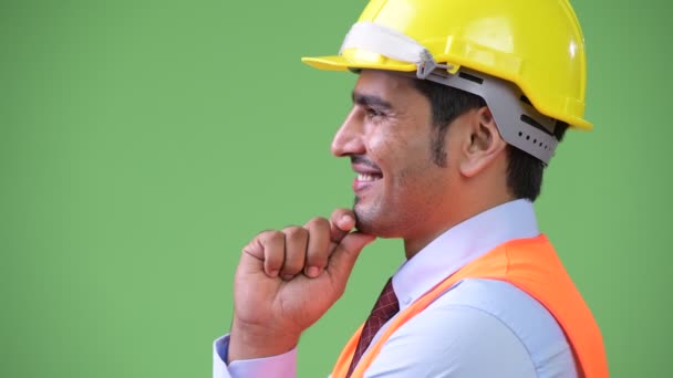 Profil bild av ung stilig Persiska man byggnadsarbetare tänkande — Stockvideo