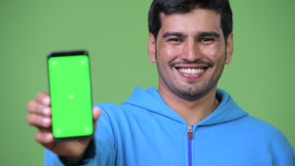 Молодой красивый персидский мужчина показывает телефон — стоковое видео