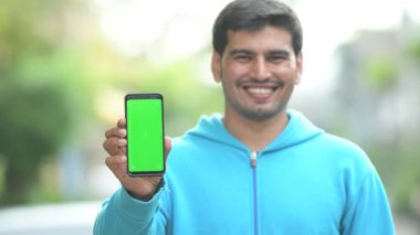 Mutlu Farsça delikanlı gösteren telefon açık havada