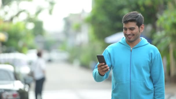 Young happy Persian man taking selfie outdoors — Stock Video