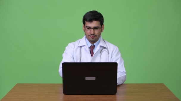 Jovem bonito persa homem médico usando laptop — Vídeo de Stock