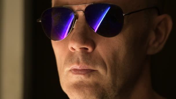 Zbliżenie: człowiek noszący okulary przeciwsłoneczne myśląc w nocy — Wideo stockowe