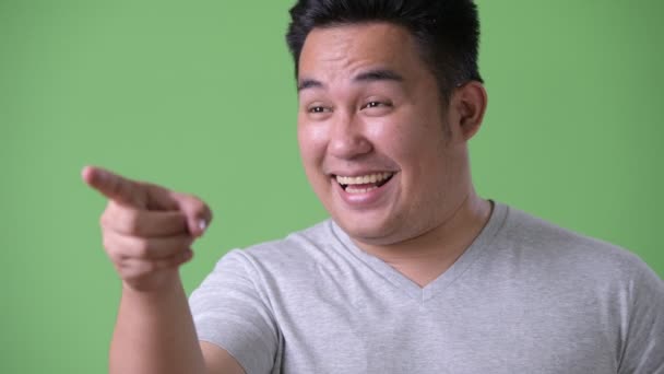 Joven guapo sobrepeso asiático hombre contra verde fondo — Vídeo de stock