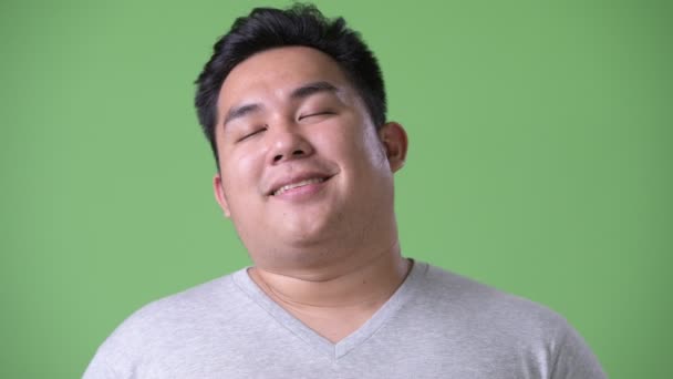 年轻英俊肥胖亚洲人反对绿色背景 — 图库视频影像