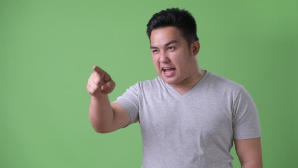 Jovem bonito acima do peso asiático homem contra fundo verde — Vídeo de Stock