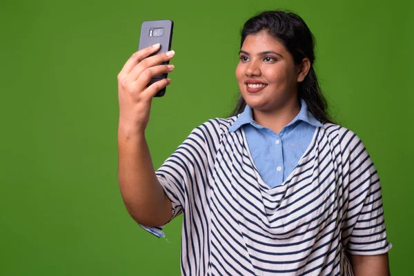 Giovane sovrappeso bella donna d'affari indiana contro sfondo verde — Foto Stock