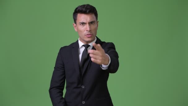 Joven guapo empresario hispano contra fondo verde — Vídeos de Stock