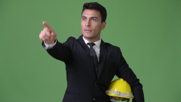 Young handsome Hispanic businessman against green background — Stock Video