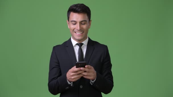 Ung vacker Hispanic affärsman mot grön bakgrund — Stockvideo