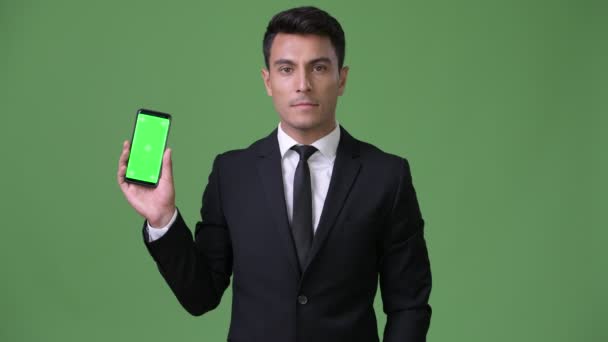 Fiatal jóképű spanyol üzletember zöld háttér — Stock videók