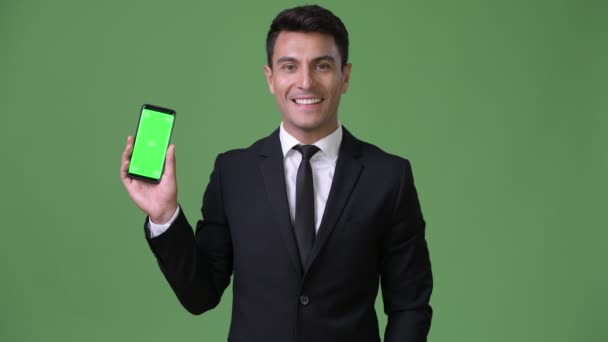 Genç yakışıklı İspanyol işadamı yeşil bir arka plana dayanır — Stok video