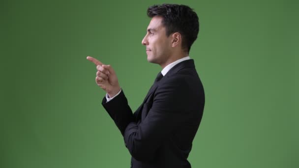 Joven guapo empresario hispano contra fondo verde — Vídeo de stock