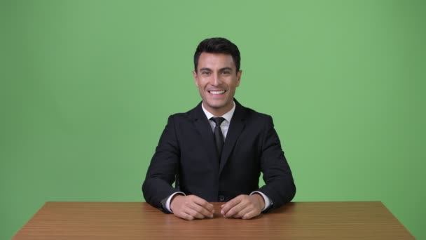 Genç yakışıklı İspanyol işadamı yeşil bir arka plana dayanır — Stok video