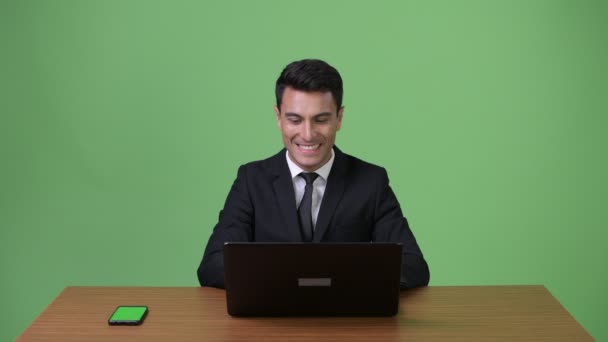 Молодий красивий іспаномовні бізнесмен на зеленому тлі — стокове відео