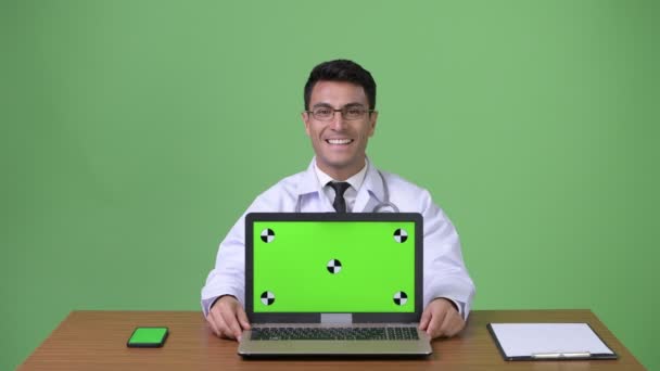 Joven guapo médico hispano contra fondo verde — Vídeos de Stock