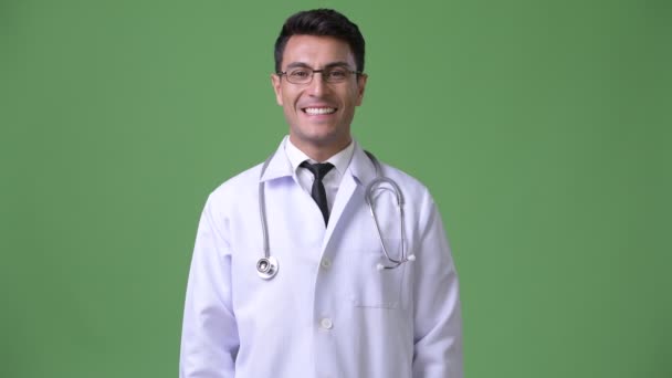 工作室拍摄的年轻英俊的拉美裔男子医生反对色度键与绿色背景 — 图库视频影像