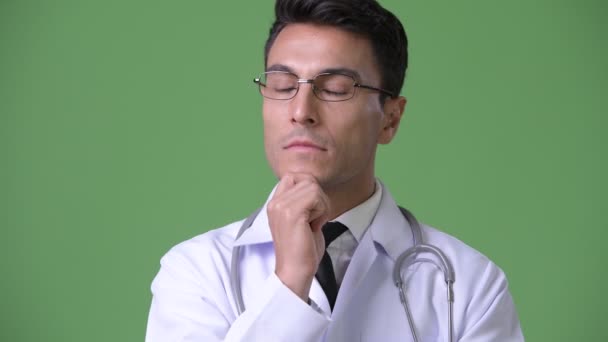 年轻英俊的拉美裔男子医生反对绿色背景 — 图库视频影像