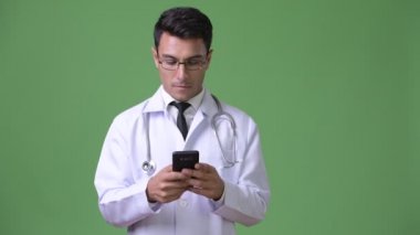 Genç yakışıklı İspanyol adam doktor yeşil bir arka plana dayanır