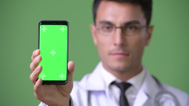 Joven guapo médico hispano contra fondo verde — Vídeos de Stock