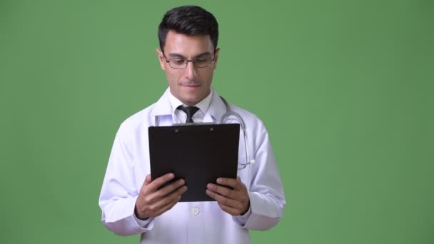 Joven guapo médico hispano contra fondo verde — Vídeos de Stock