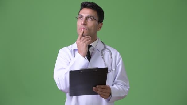 Giovane bello ispanico uomo medico contro verde sfondo — Video Stock