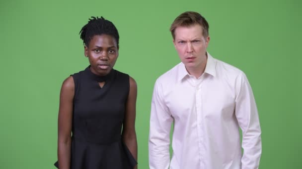Två unga multietniska business par ger tummen ner tillsammans — Stockvideo