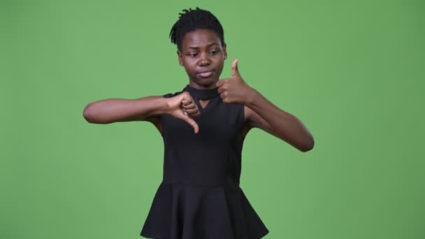 Молодая красивая африканская бизнесвумен выбирает между большим и большим пальцами вниз — стоковое видео