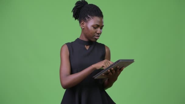 Jeune belle femme d'affaires africaine utilisant une tablette numérique — Video