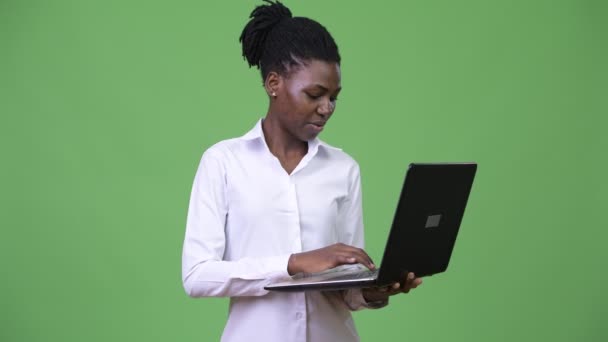 Giovane bella donna d'affari africana utilizzando il computer portatile — Video Stock