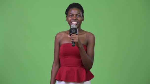 Νεαρή όμορφη γυναίκα αφρικανική χρησιμοποιώντας μικρόφωνο — Αρχείο Βίντεο
