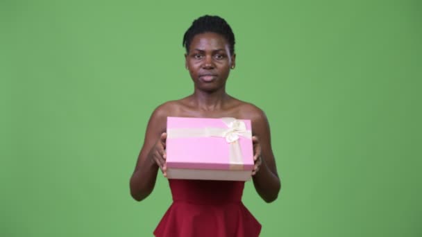 Young beautiful African woman giving gift box — Stock Video