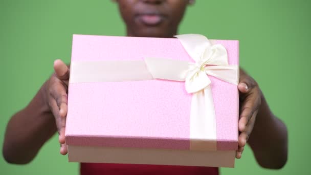 Joven mujer africana feliz dando caja de regalo — Vídeos de Stock