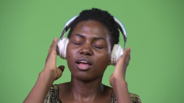 Young beautiful African woman listening to music — Stock Video