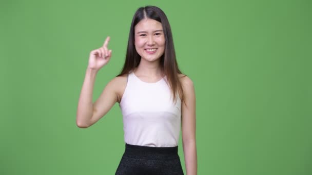 Young beautiful Asian businesswoman pointing up — Stock Video