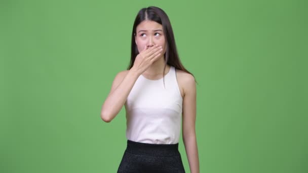 Joven hermosa mujer de negocios asiática cubriendo la boca mientras busca culpable — Vídeo de stock